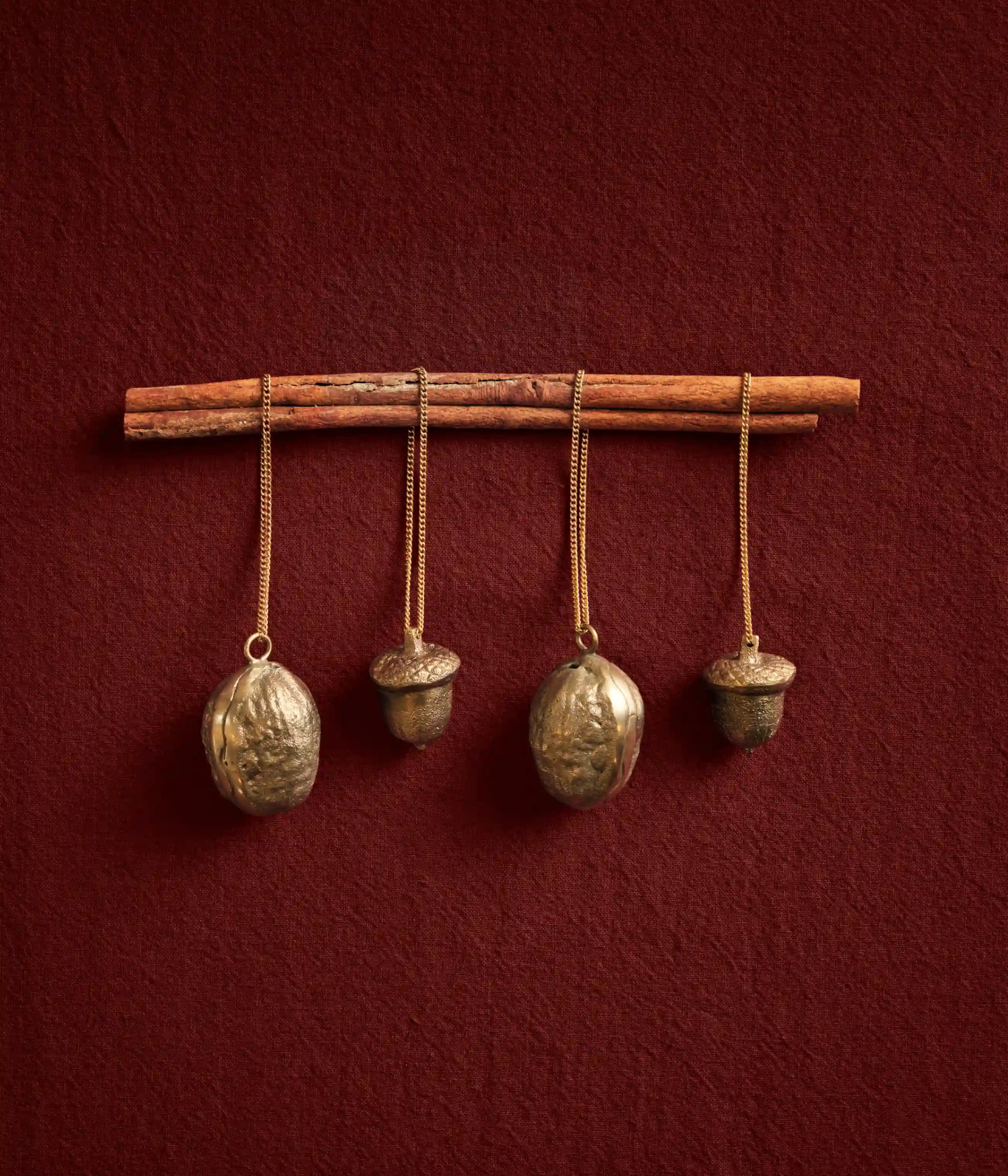 Juldekorationer, fyra ornament formade som nötter och ekollon i kedjor upphängda från en pinne