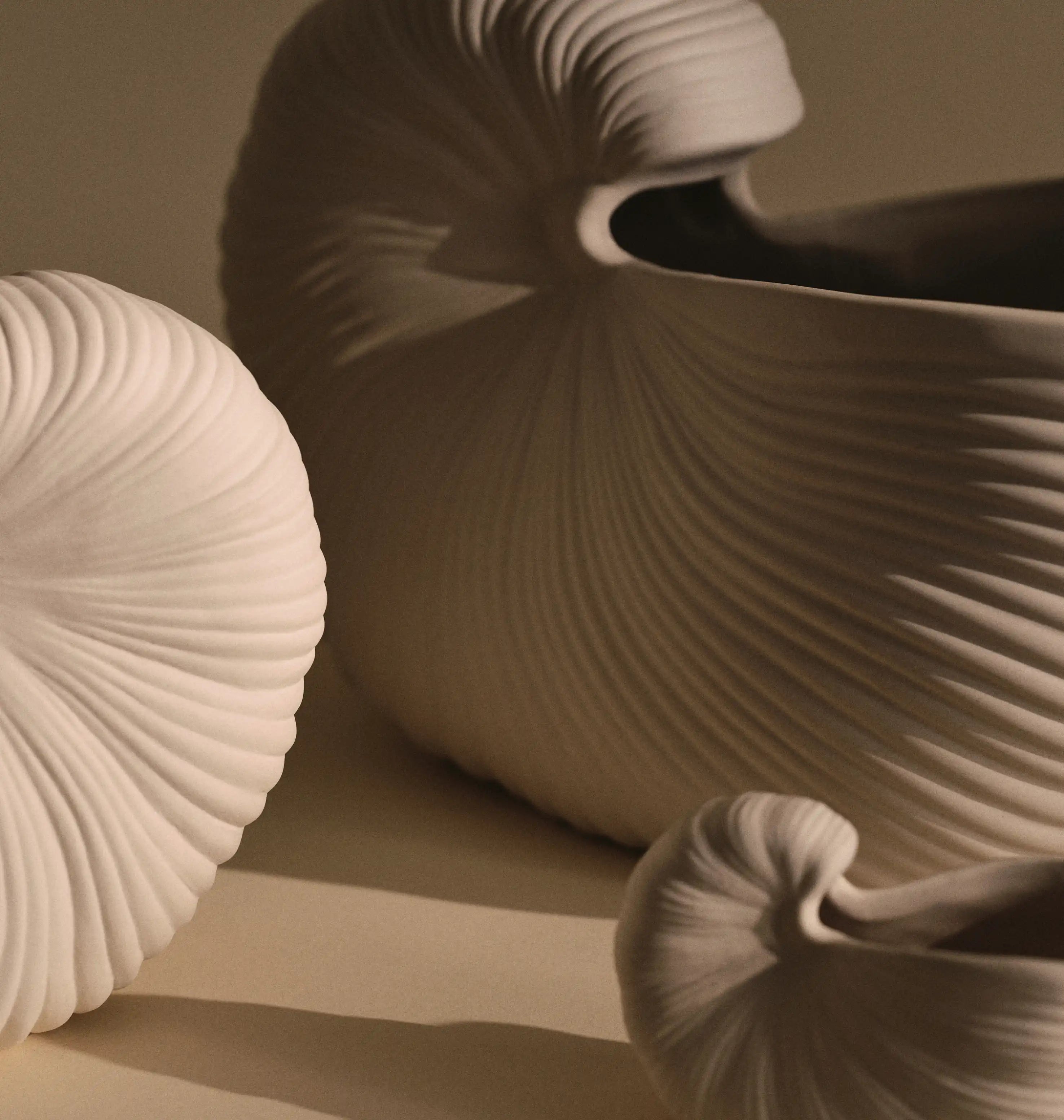 Ferm Living klassiker, närbild av tre räfflade snäckformade vaser i off-white